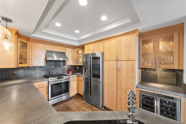 a kitchen with refrigerator a stove a sink and a large window
