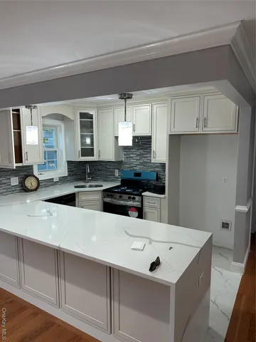 a kitchen with a sink and white cabinets