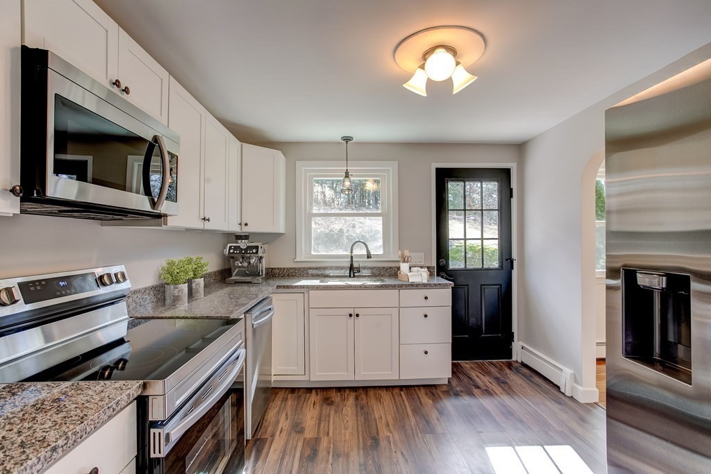 31 Sargent Road Bolton, MA 01740 - Photo 5 of 11 a kitchen with granite countertop a stove a sink and wooden floor
