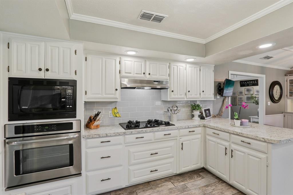 149 South Moore Road Coppell, TX 75019 - Photo 12 of 40 a kitchen with granite countertop white cabinets white stainless steel appliances and sink