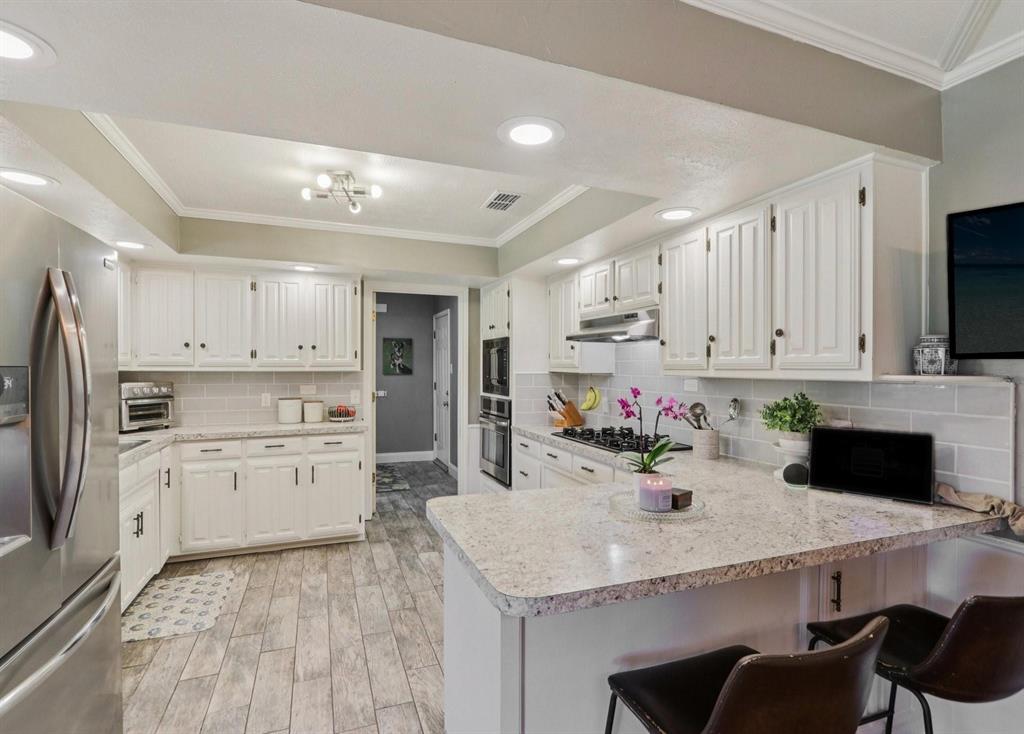 149 South Moore Road Coppell, TX 75019 - Photo 14 of 40 a kitchen with a stove a refrigerator and white cabinets