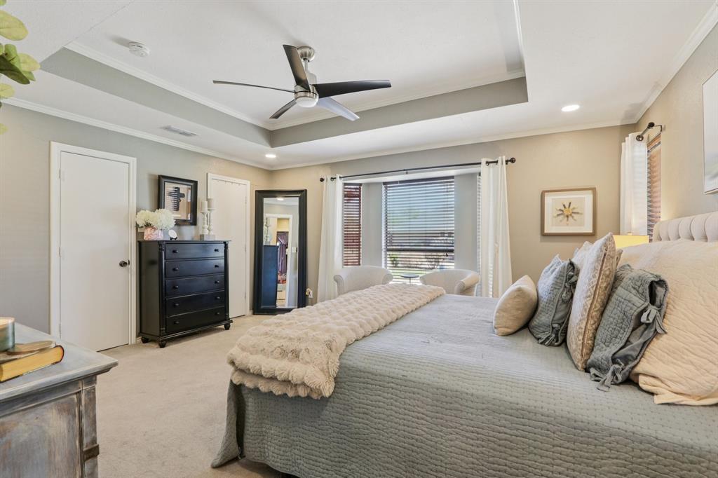 149 South Moore Road Coppell, TX 75019 - Photo 19 of 40 a bedroom with a large bed a flat tv screen and dresser