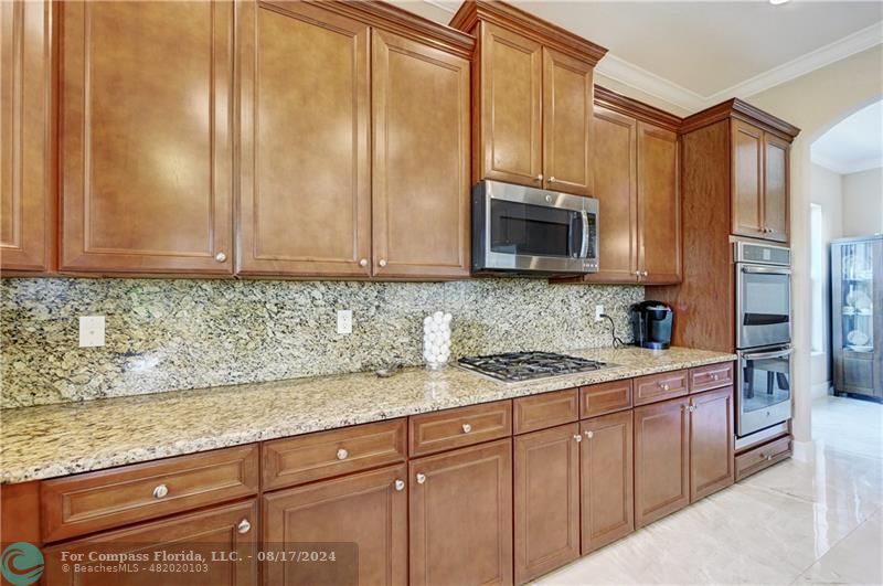 8631 Lakeside Bend Parkland, FL 33076 - Photo 20 of 71 a kitchen with stainless steel appliances granite countertop a sink a stove and a microwave oven