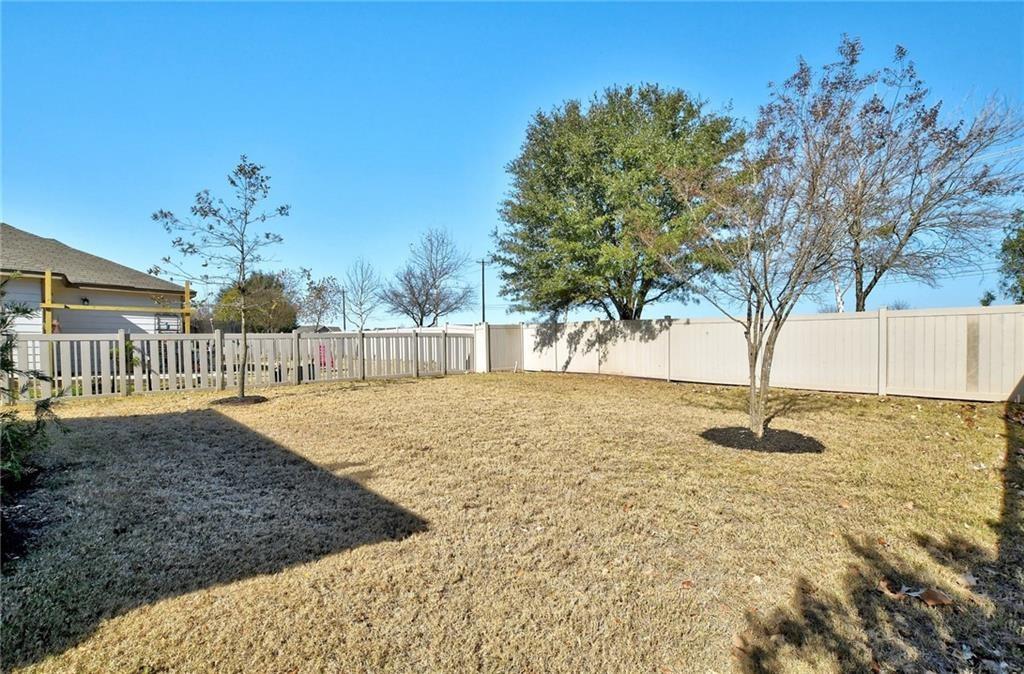 201 Edwin Kyle, TX 78640 - Photo 19 of 21 Expansive backyard featuring a large grass area, perimeter fencing, and mature trees