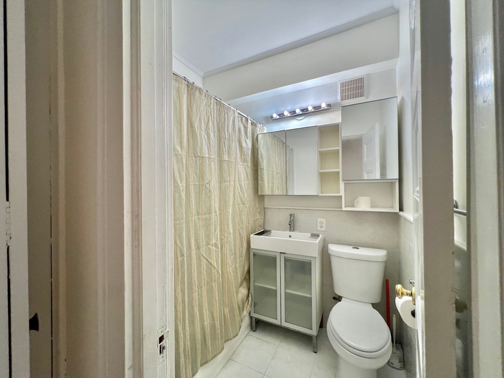 21 Beacon Street, Unit 6T Boston, MA 02108 - Photo 13 of 28 a white toilet sitting next to a bathroom sink