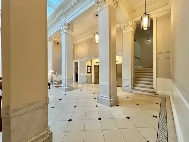 a view of a hallway with wooden floor and a bathroom