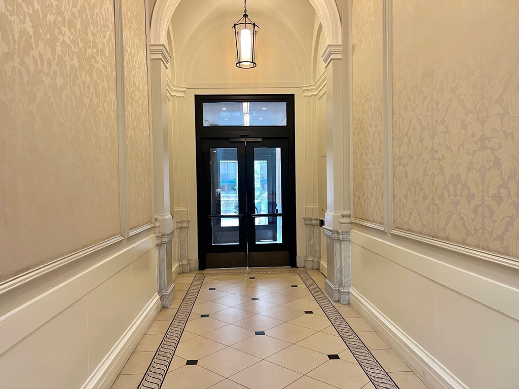 21 Beacon Street, Unit 6T Boston, MA 02108 - Photo 21 of 28 a view of a hallway with wooden floor and a bathroom