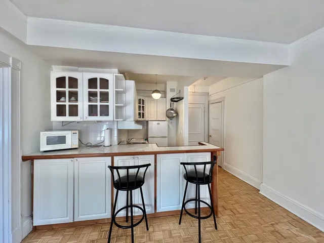 a kitchen with stainless steel appliances a table and chairs in it