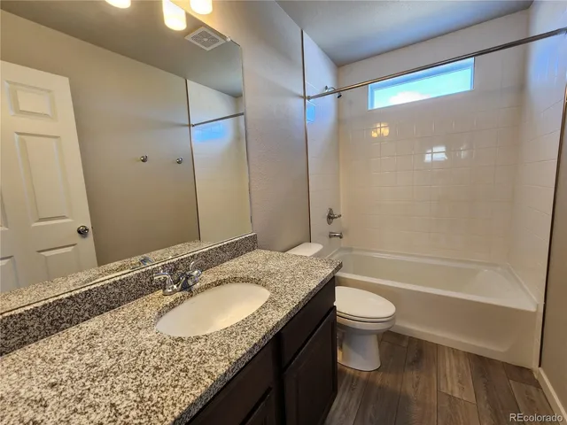 a bathroom with a granite countertop sink toilet and shower