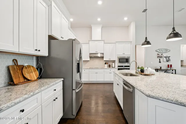 a bedroom with a large bed a chandelier and closet