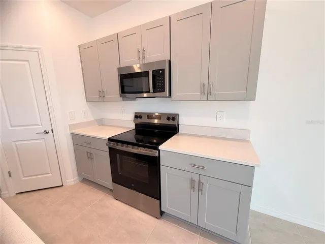 a kitchen with white cabinets and white appliances