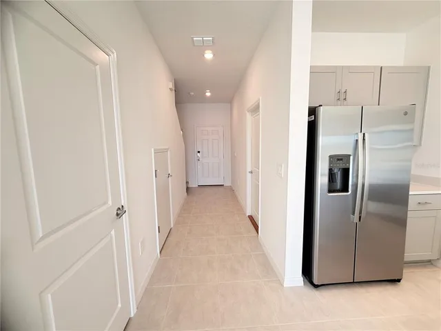 a view of a refrigerator in kitchen and entryway