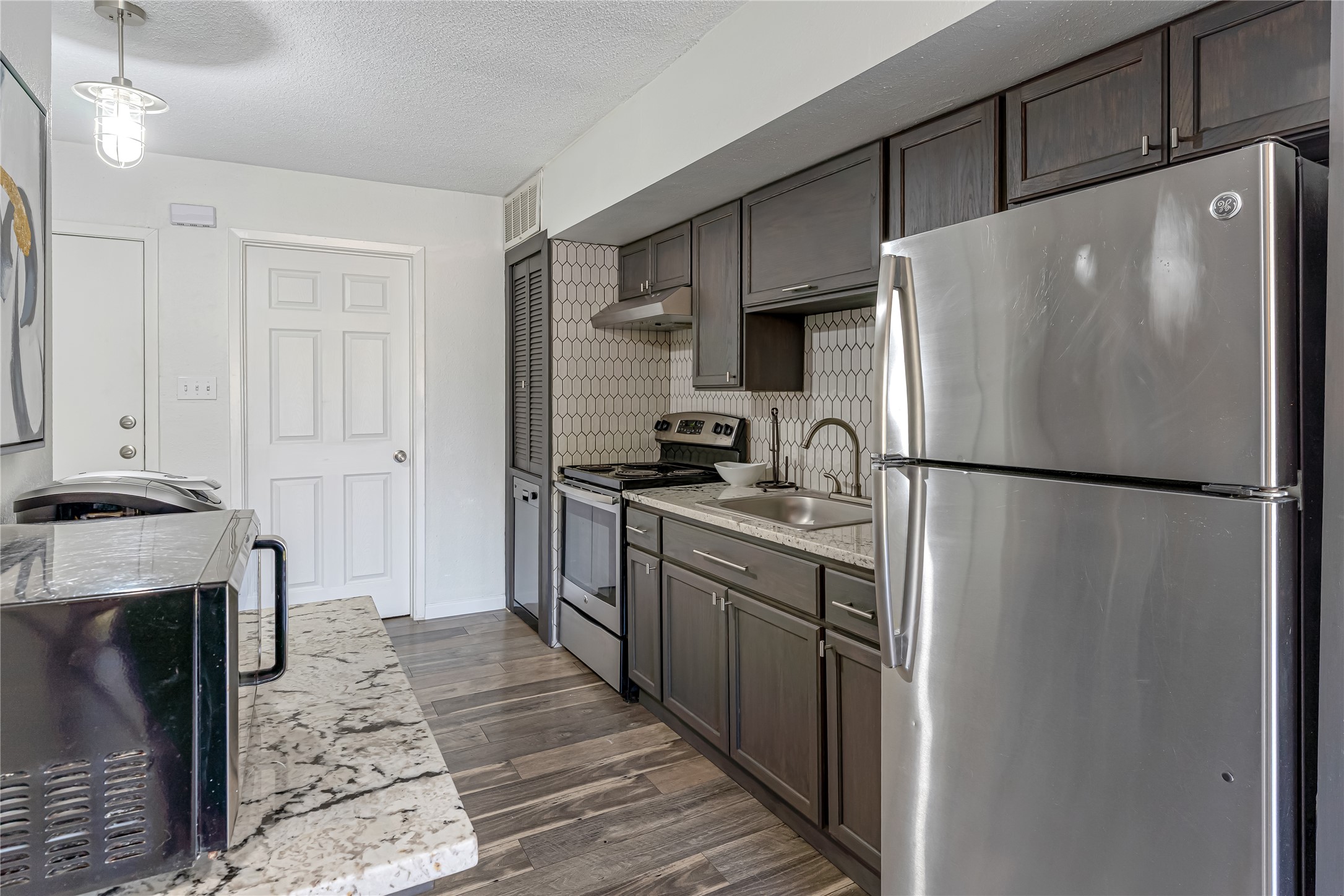 12900 Walden Road, Unit 502E Montgomery, TX 77356 - Photo 5 of 31 a kitchen with granite countertop a refrigerator and a stove