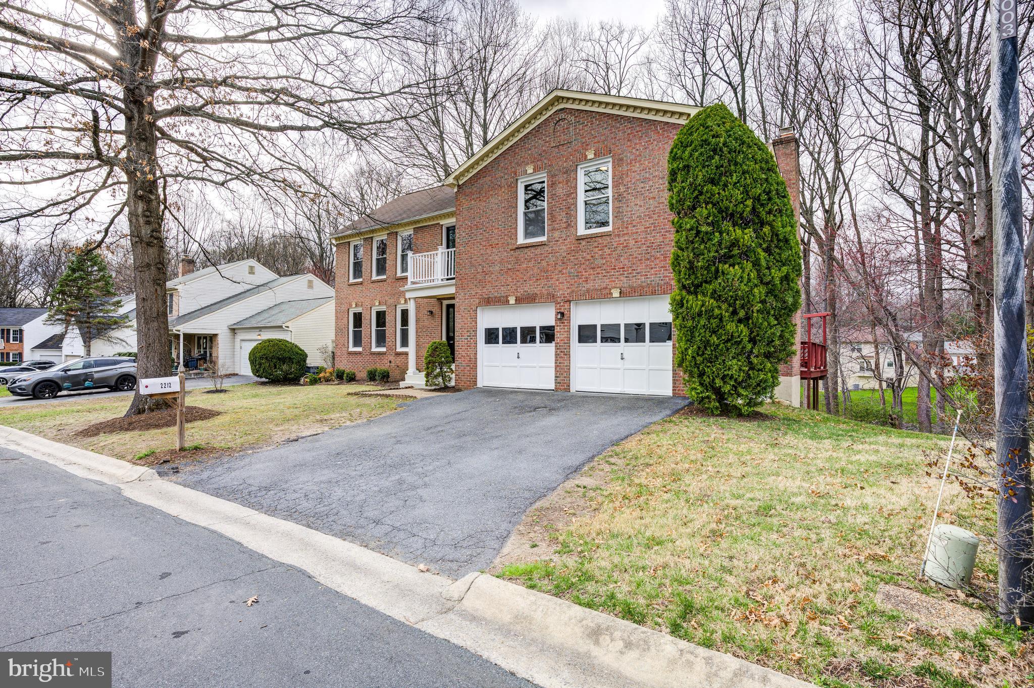 a front view of a house with a yard and trees