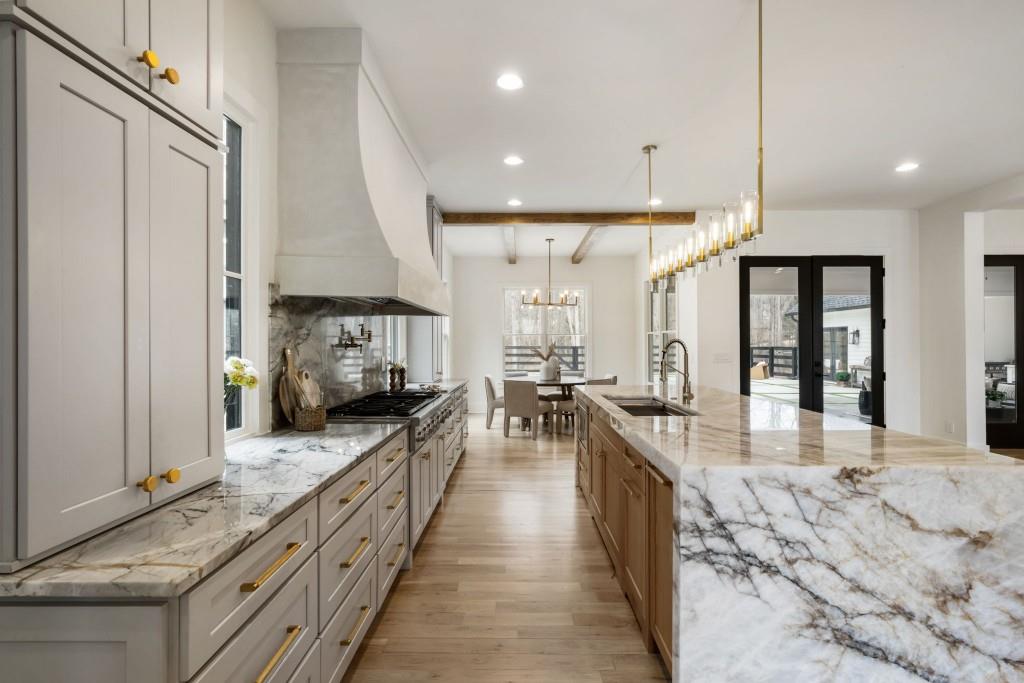 1980 Birmingham Road Milton, GA 30004 - Photo 18 of 78 a large kitchen with stainless steel appliances kitchen island granite countertop a large counter top a stove a chimney a sink and a refrigerator