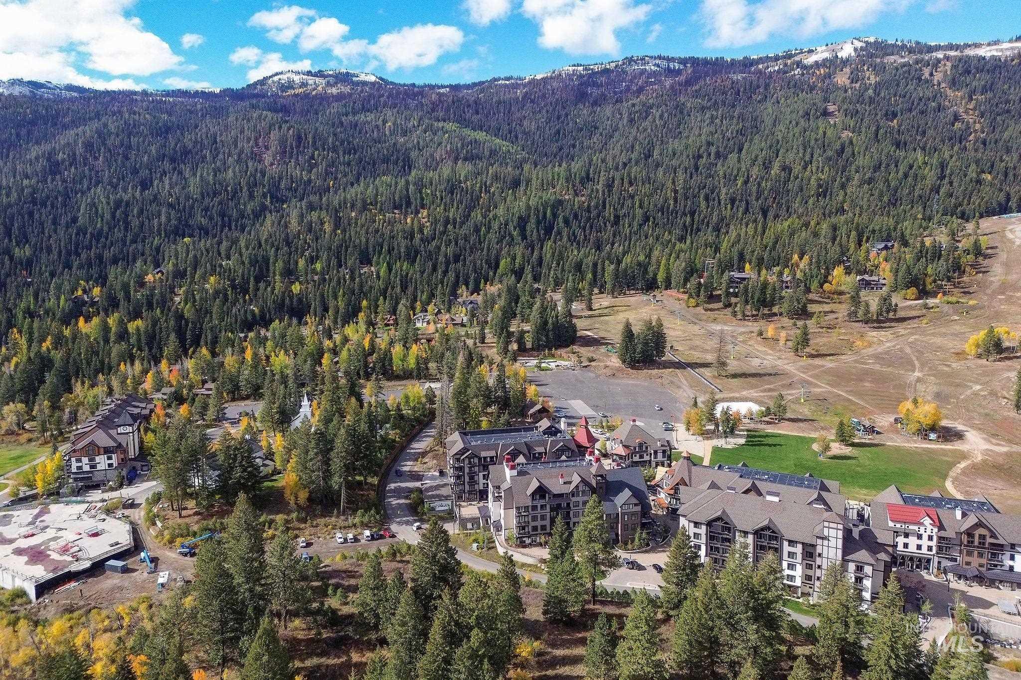 720 Village Drive, Unit 311 Donnelly, ID 83615 - Photo 32 of 37 Aerial view of property and surrounding area featuring mountains and a heavily wooded area