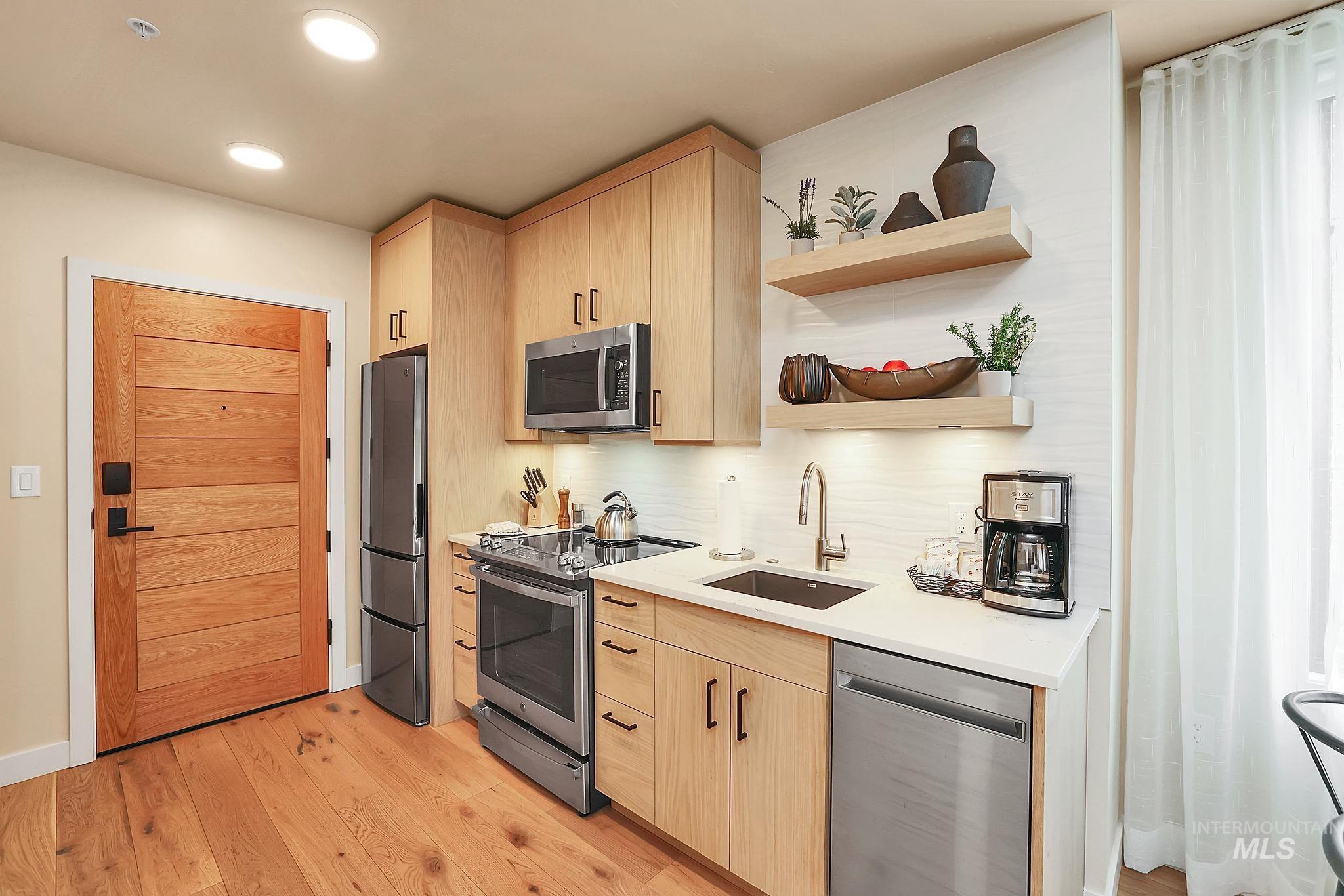 720 Village Drive, Unit 311 Donnelly, ID 83615 - Photo 8 of 37 Kitchen featuring open shelves, light brown cabinetry, appliances with stainless steel finishes, light wood-type flooring, and recessed lighting