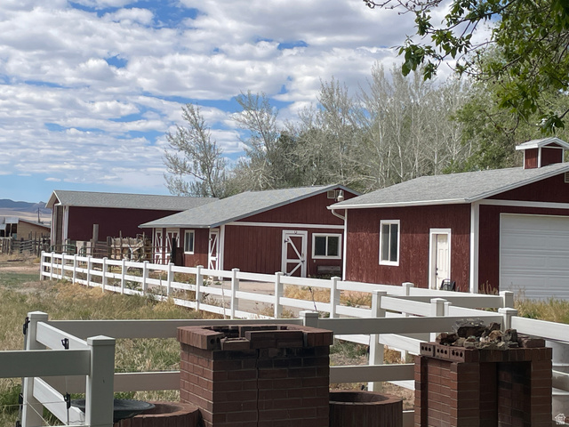 438 East Main Street Elsinore, UT 84724 - Photo 13 of 43 Distant RV Garage, Wood shop and Detached 2 car Garage all red-sided with white trim, gray shingle roofs, and white fencing