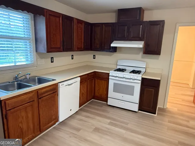 a kitchen with wooden cabinets and white appliances