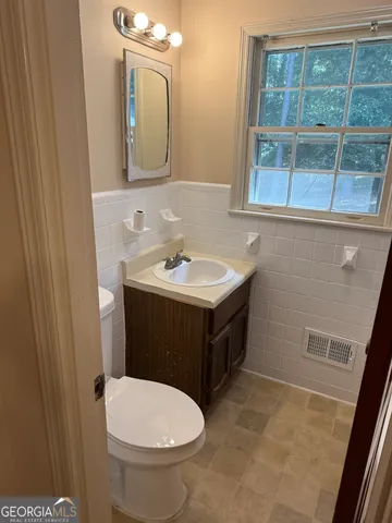 a bathroom with a toilet sink and mirror