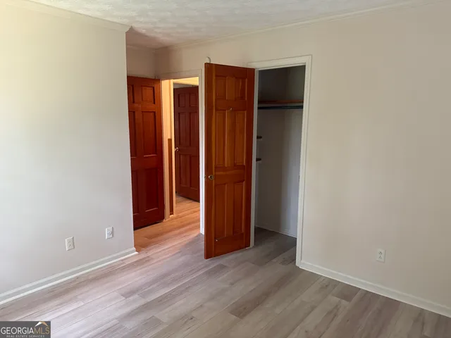 an empty room with wooden floor and closet