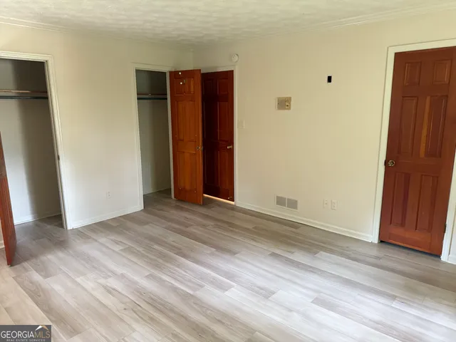 an empty room with wooden floor and closet