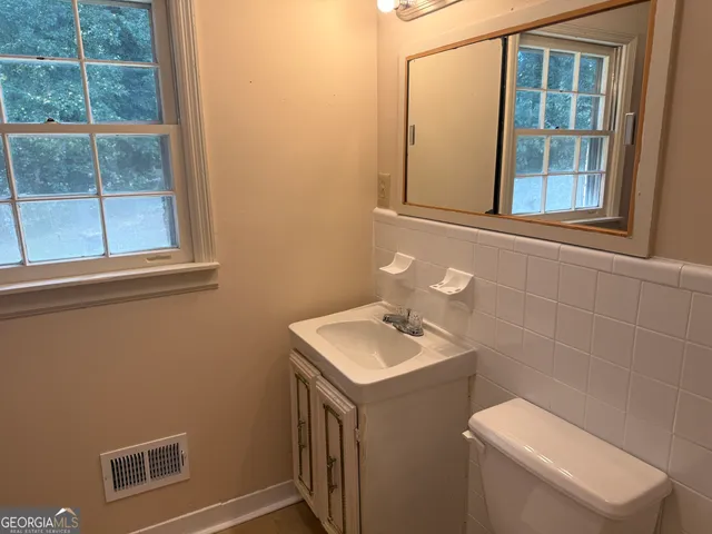 a bathroom with a toilet sink and mirror