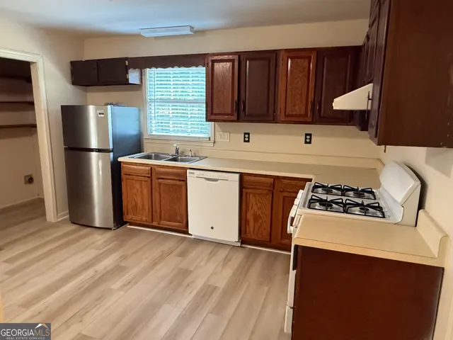 a kitchen with a stove a sink and a refrigerator