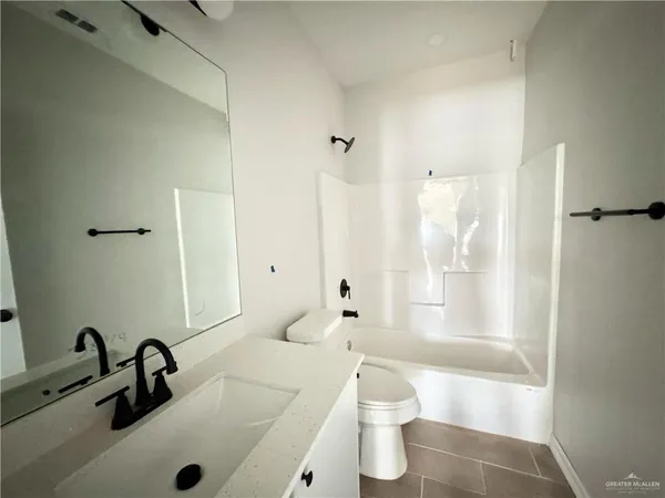 a bathroom with a sink a toilet and a large mirror