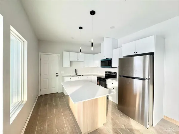 a kitchen with stainless steel appliances a refrigerator sink and cabinets
