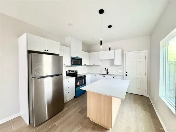 a kitchen with stainless steel appliances a refrigerator sink and cabinets