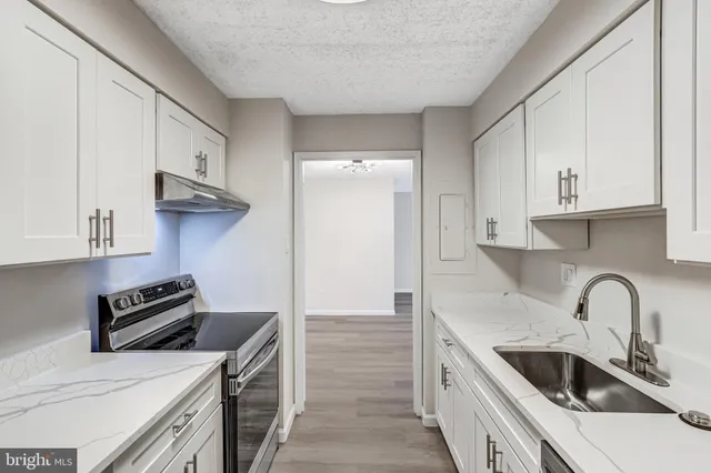 a kitchen with stainless steel appliances granite countertop a sink and a stove