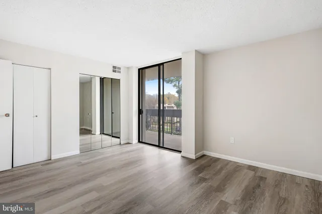 an empty room with wooden floor and sliding door