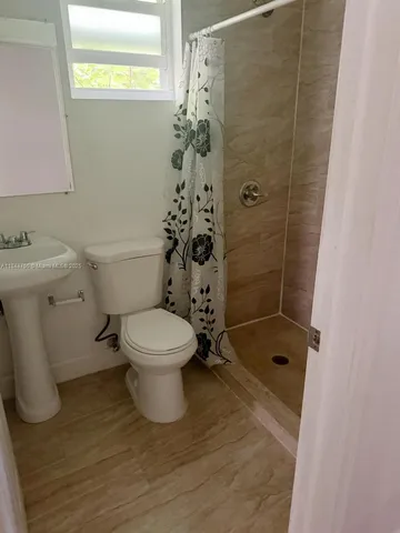 a bathroom with a toilet and a shower