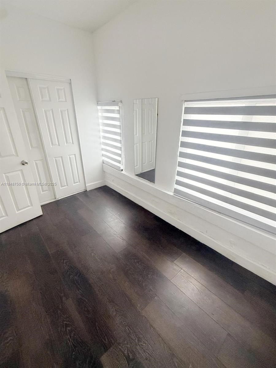 337 Southwest 10th Avenue, Unit 3 Miami, FL 33130 - Photo 5 of 7 an empty room with wooden floor and windows