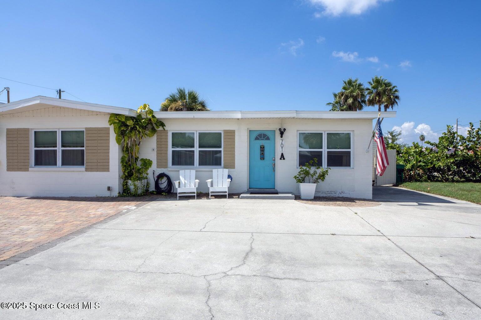 701 South Orlando Avenue, Unit A Cocoa Beach, FL 32931 - Photo 1 of 13 a front view of a house with a yard and a garage