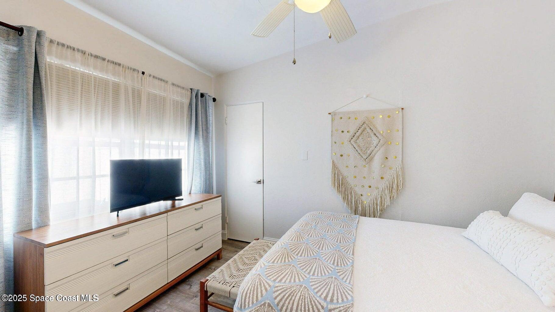 701 South Orlando Avenue, Unit A Cocoa Beach, FL 32931 - Photo 11 of 13 a bedroom with a bed and a flat screen tv