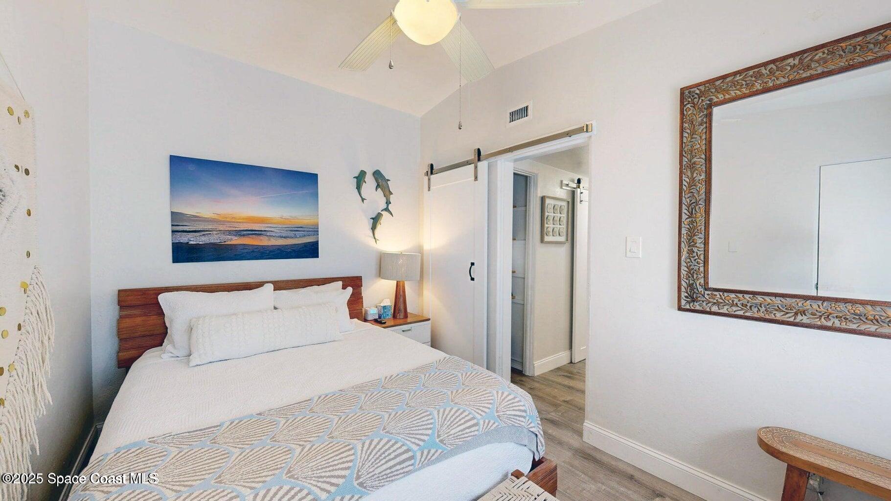 701 South Orlando Avenue, Unit A Cocoa Beach, FL 32931 - Photo 12 of 13 a bedroom with a bed and a painting on the wall