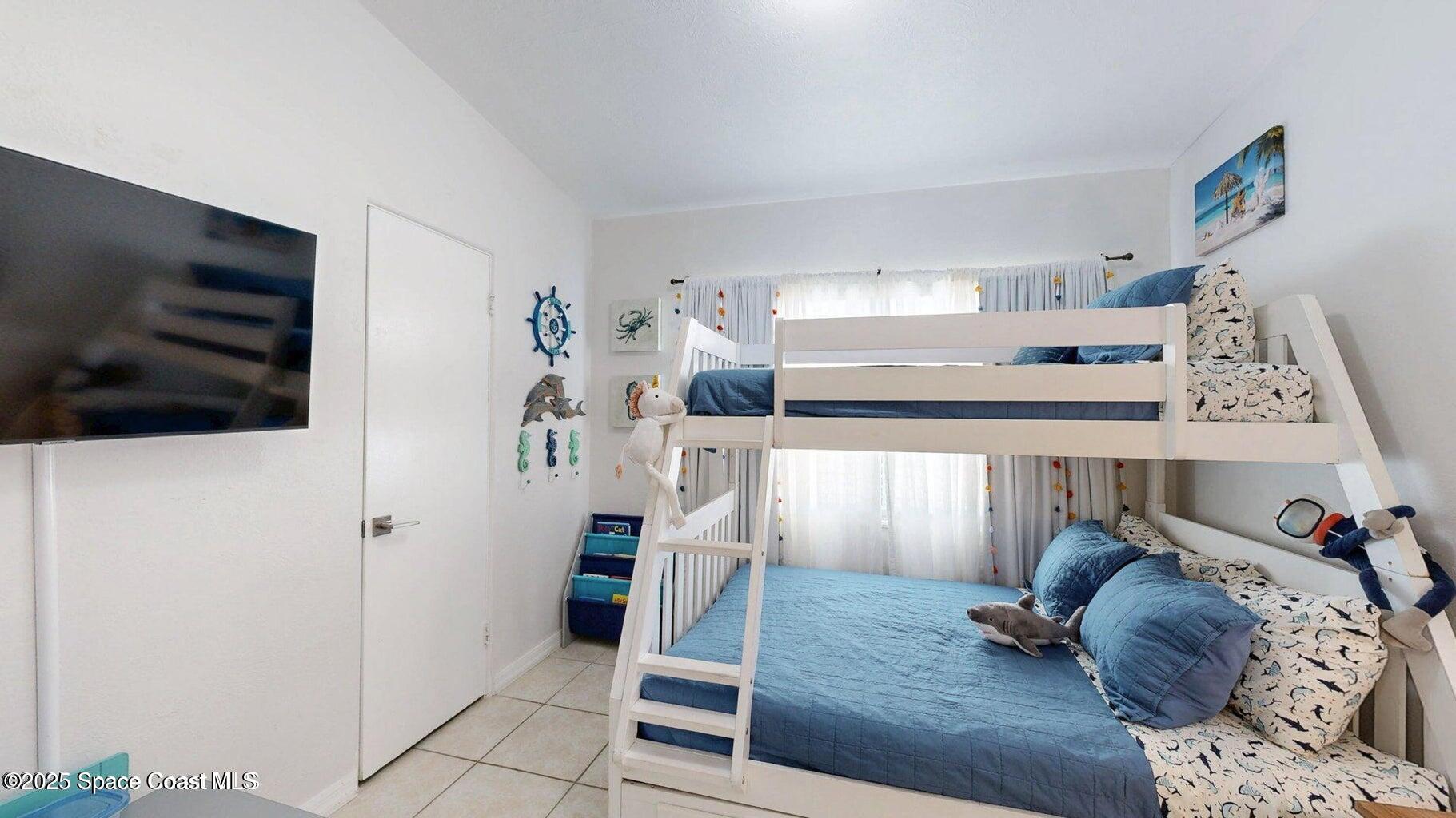 701 South Orlando Avenue, Unit A Cocoa Beach, FL 32931 - Photo 9 of 13 a living room with furniture and a flat screen tv