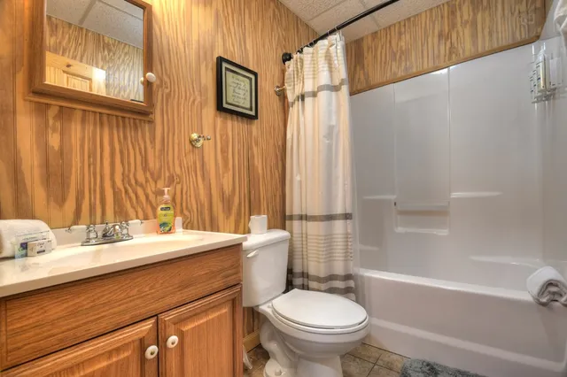 a bedroom with a bed and a dresser next to a window