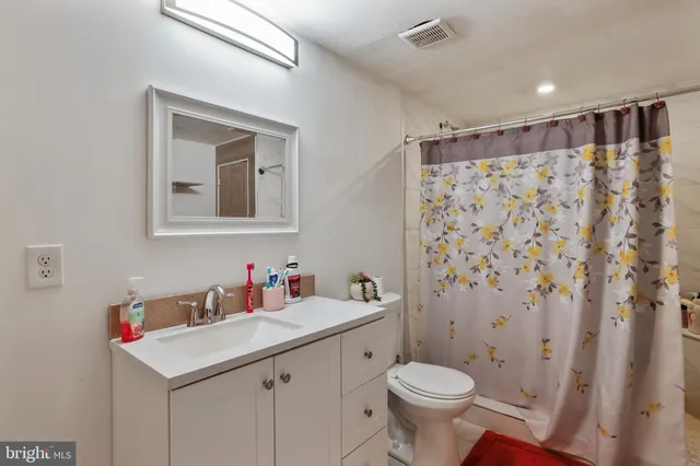 a backyard of a house with a garden and covered with tall trees