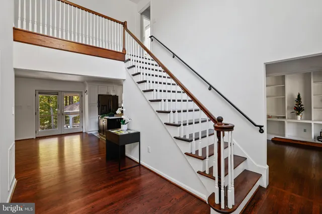 a view of staircase with lots of frames on wall and wooden floor