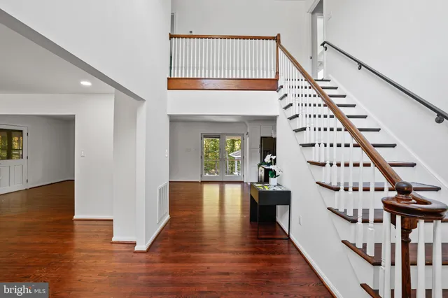 an empty room with wooden floor and staircase