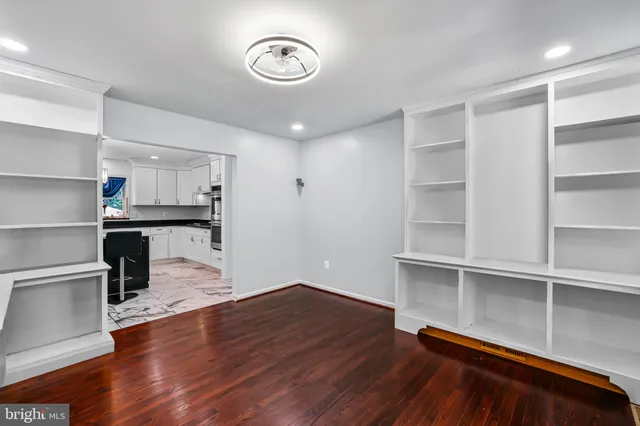 a kitchen with stainless steel appliances granite countertop a refrigerator a sink dishwasher a stove and a dining table with wooden floor