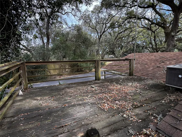 a view of backyard with wooden fence and large trees