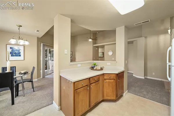 a kitchen with a sink a refrigerator and chairs