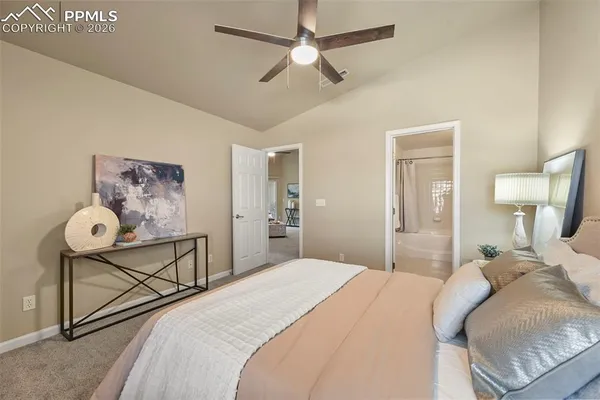 a bedroom with a bed and lamp on the dresser