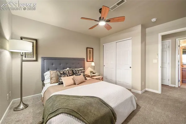 a bedroom with a large bed and a chandelier
