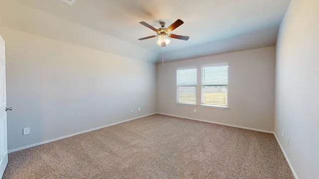 an empty room with closet and ceiling fan