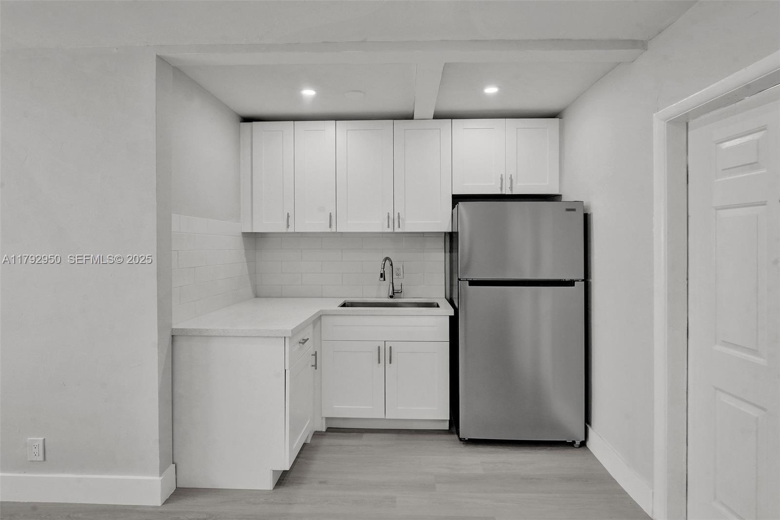 5657 Grant Street Hollywood, FL 33021 - Photo 26 of 59 a kitchen with a refrigerator sink stove and cabinets